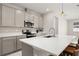 Bright kitchen features stainless steel appliances, grey cabinets, island with bar seating, and quartz countertops at 236 Pink Ibis Bnd, St Cloud, FL 34772