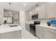 Bright kitchen features stainless steel appliances, grey cabinets, and quartz countertops at 236 Pink Ibis Bnd, St Cloud, FL 34772