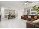 Spacious living room features tile flooring, a ceiling fan, and a large sofa in open layout to kitchen at 236 Pink Ibis Bnd, St Cloud, FL 34772