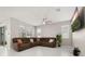 Spacious living room features tile flooring, a ceiling fan, large windows and a large sofa at 236 Pink Ibis Bnd, St Cloud, FL 34772