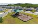 Aerial view of community playground with swings and covered play structure at 236 Pink Ibis Bnd, St Cloud, FL 34772