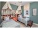 Bright bedroom featuring two beds, unique canopies and wood-paneled accent wall at 2454 Dream Home Ct, St Cloud, FL 34772
