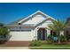 A well-maintained single Gathering home, featuring a lush lawn, brick driveway, and covered entryway at 2454 Dream Home Ct, St Cloud, FL 34772