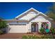 Inviting single-Gathering home with a well-manicured lawn, brick driveway, and a charming covered entrance at 2454 Dream Home Ct, St Cloud, FL 34772