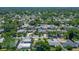 An aerial view highlights a sprawling neighborhood with tree coverage and glimpses of swimming pools and patios at 2817 Prince John Rd, Winter Park, FL 32792