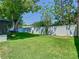 A lush green backyard with healthy grass, surrounded by a new-looking white fence and mature trees at 2817 Prince John Rd, Winter Park, FL 32792
