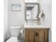 Stylish bathroom features a wood vanity, framed mirror, and elegant light fixture at 2817 Prince John Rd, Winter Park, FL 32792