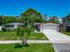 Charming single-story home with lush landscaping, a well-manicured lawn, and a two-car garage at 2817 Prince John Rd, Winter Park, FL 32792