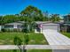 Charming single-story home featuring a well-manicured lawn, decorative driveway, and attached two-car garage at 2817 Prince John Rd, Winter Park, FL 32792