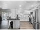 Bright open-concept kitchen with white cabinets, stainless steel appliances, and a peninsula island at 2817 Prince John Rd, Winter Park, FL 32792