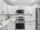 Modern kitchen featuring sleek white cabinets, stainless steel appliances, and stylish backsplash at 2817 Prince John Rd, Winter Park, FL 32792