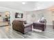 The open-concept living room features modern decor, grey wood-look floors, and abundant natural light at 2817 Prince John Rd, Winter Park, FL 32792