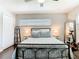 Bedroom with hardwood floors, a metal frame bed, bright window, and full-length mirror at 2817 Prince John Rd, Winter Park, FL 32792