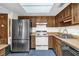 Functional kitchen featuring a refrigerator, updated appliances, and neutral countertops at 3218 Cimarron Dr, Orlando, FL 32829