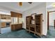 Living room adjacent to kitchen area with wooden built-in shelving and vintage lamp at 3218 Cimarron Dr, Orlando, FL 32829