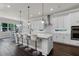 Open kitchen featuring a center island with bar seating, white cabinets, and stainless steel appliances at 3417 Michigan St, Lake Mary, FL 32746