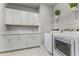 Well-lit laundry room featuring white cabinets and modern washer and dryer at 3417 Michigan St, Lake Mary, FL 32746