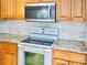 Modern kitchen boasts stone countertops, subway tile backsplash, white appliances, and wooden cabinets at 3461 Home Town Ln, St Cloud, FL 34769