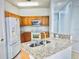Well-lit kitchen displays granite countertops, wood cabinets, stainless steel appliances, and an island with a sink at 3461 Home Town Ln, St Cloud, FL 34769