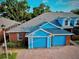 Bright brick townhome with a two-car garage, complemented by lush greenery and a well-maintained roof at 3461 Home Town Ln, St Cloud, FL 34769