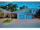 Charming brick townhome featuring a vibrant blue facade, two-car garage, and manicured front lawn at 3461 Home Town Ln, St Cloud, FL 34769