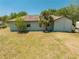 Back view of home featuring large backyard with mature landscaping and trees at 3975 Rambler Ave, St Cloud, FL 34772