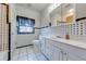 Bathroom with a vanity and sink, toilet, tiled walls, and a window for natural light at 3975 Rambler Ave, St Cloud, FL 34772