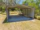 Exterior metal carport in backyard with surrounding trees and green grass at 3975 Rambler Ave, St Cloud, FL 34772