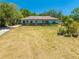 Inviting single-story home boasts a lush green lawn, mature trees, and a welcoming facade under the bright sun at 3975 Rambler Ave, St Cloud, FL 34772