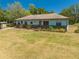 Inviting single-story home featuring a brick foundation accent and lush front lawn under a clear blue sky at 3975 Rambler Ave, St Cloud, FL 34772