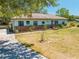 Charming single-story home with a covered carport, complemented by a tree-lined yard and long driveway at 3975 Rambler Ave, St Cloud, FL 34772