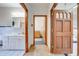 Hallway with a tile floor, a bathroom on the left, and an open door leading outside on the right at 3975 Rambler Ave, St Cloud, FL 34772