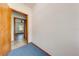 Hallway with blue carpet, a glimpse of a bedroom with wood flooring and a ceiling fan in the background at 3975 Rambler Ave, St Cloud, FL 34772