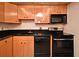 A galley kitchen features black appliances, wood cabinets, and dark counters at 400 E Colonial Dr # 1003, Orlando, FL 32803