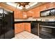 The kitchen features black appliances, wood cabinets, and a tiled floor at 400 E Colonial Dr # 1003, Orlando, FL 32803