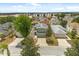 An eye-level aerial view reveals a well-maintained green home nestled in a vibrant neighborhood surrounded by mature trees at 429 Rona Ln, Davenport, FL 33897