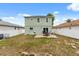 The backyard features a stone patio, a well-maintained lawn, and a privacy fence perfect for outdoor entertaining at 429 Rona Ln, Davenport, FL 33897
