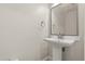 Pedestal sink with tile backsplash and mirror, in a well-lit bathroom at 429 Rona Ln, Davenport, FL 33897
