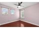 Pink bedroom with wood floor, three windows and ceiling fan with light at 429 Rona Ln, Davenport, FL 33897