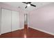 Clean bedroom with pink walls, ceiling fan, closet, and access to stairway at 429 Rona Ln, Davenport, FL 33897