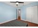 Comfortable bedroom featuring light blue walls, ceiling fan, and closet at 429 Rona Ln, Davenport, FL 33897