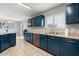 Spacious kitchen with blue cabinetry, granite countertops, stainless steel appliances, and natural light at 429 Rona Ln, Davenport, FL 33897