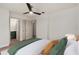 Staged bedroom featuring wood floors, ceiling fan, with doorway to the bathroom at 5326 Weirwood Ave, Orlando, FL 32810