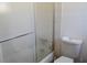 Bathroom featuring a shower-tub combo with frosted glass doors and a standard toilet at 5502 Minaret Ct, Orlando, FL 32821