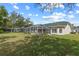 Backyard with a screened-in pool, patio, and spacious lawn with mature trees at 58 Golf View Dr, Ocala, FL 34472
