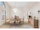 Dining room with a glass table, wooden chairs, a chandelier, and a large window at 58 Golf View Dr, Ocala, FL 34472