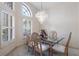 Bright dining area featuring a glass table, chandelier lighting, and large arched window at 58 Golf View Dr, Ocala, FL 34472