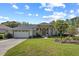 Charming single-story home with a well-manicured lawn, arched windows, and a two-car garage at 58 Golf View Dr, Ocala, FL 34472