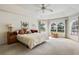 Large main bedroom featuring large windows, a ceiling fan, and carpeted floors at 58 Golf View Dr, Ocala, FL 34472