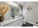 Modern bathroom featuring granite countertops, a decorative mirror, and stylish fixtures at 634 Chadbury Way, Kissimmee, FL 34744